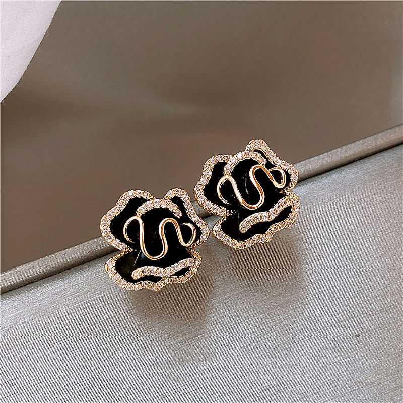 Elegante schwarze Lotusblumenohrringe in Gold